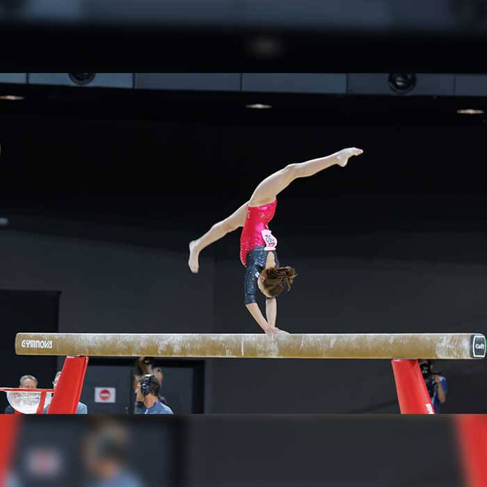 Gymnast (13-15) posing on balance beam, side view Stock Photo - Alamy