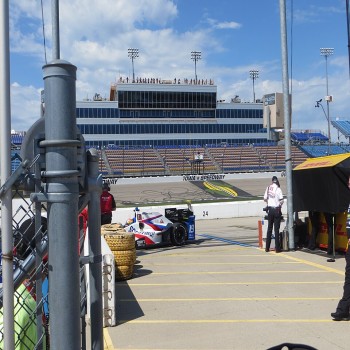 View of the Iowa Speedway including the start/finish line, the grandstands, pit lane, and the pit wall.