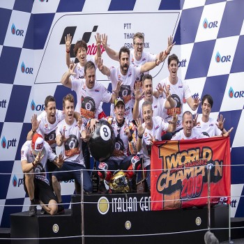Marc Márquez, celebrating with his team on the podium after winning his sixth MotoGP world championship title and the 2019 Thai Grand Prix.