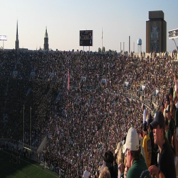 A view from the east side of the Notre Dame Stadium showing (from left to right) the Basilica of the Sacred Heart, the Golden Dome atop the Administration Building and the Hesburgh Library with the mural of Touchdown Jesus.